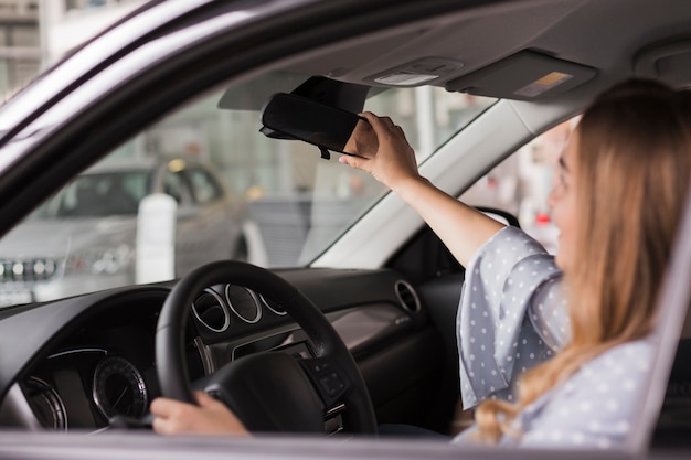 Mujer arreglando el espejo retrovisor