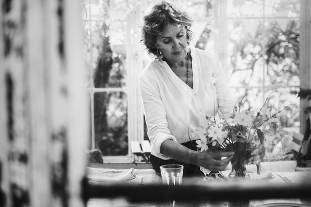 Mujer arreglando flores en un invernadero