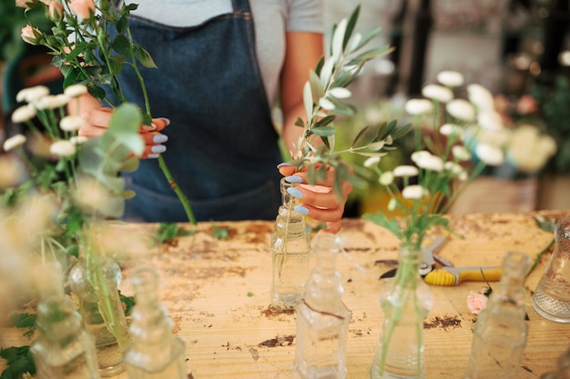 Foto gratuita mujer arreglando plantas en florero de vidrio