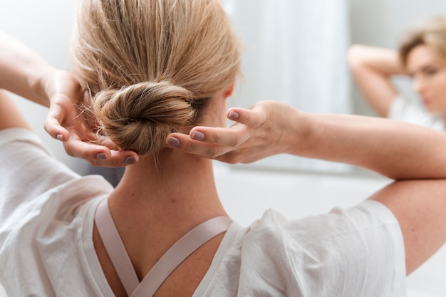 Mujer arreglando su cabello desde atrás