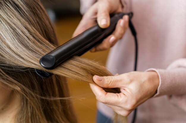Mujer arreglando su cabello en casa