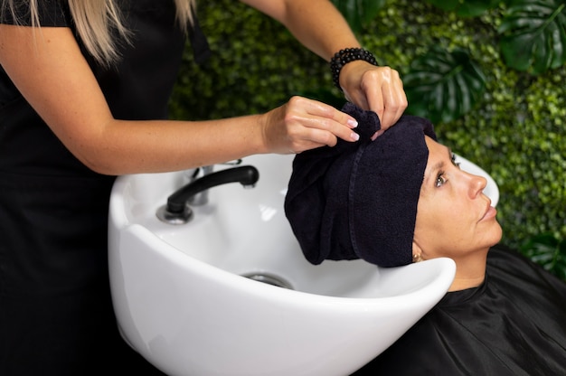 Foto gratuita mujer arreglando su cabello en el salón de belleza