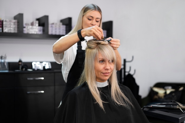 Mujer arreglando su cabello en el salón de belleza