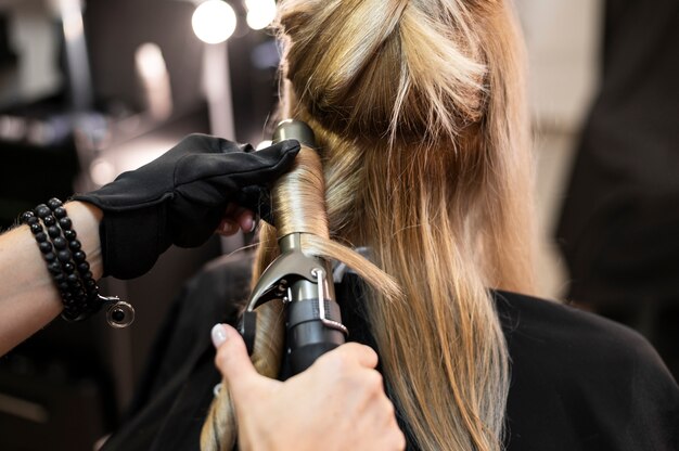 Mujer arreglando su cabello en el salón de belleza