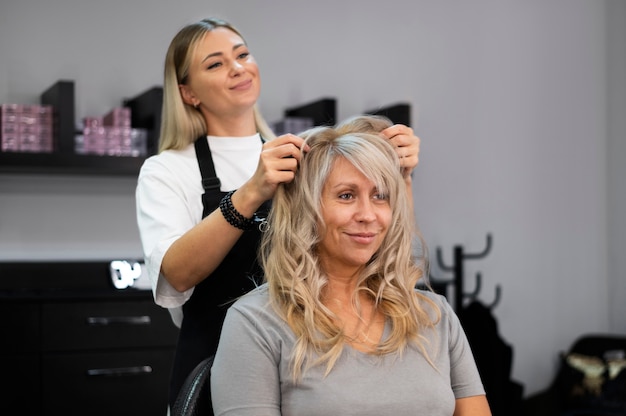 Foto gratuita mujer arreglando su cabello en el salón de belleza