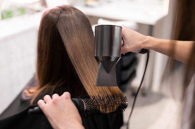 Mujer arreglando su cabello en el salón de belleza