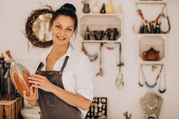 Foto gratuita mujer artesana en una tienda de cerámica