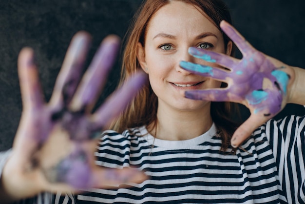 Foto gratuita mujer artista con manos pintadas