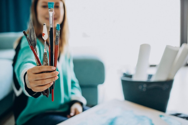 Mujer artista pintando un cuadro en casa