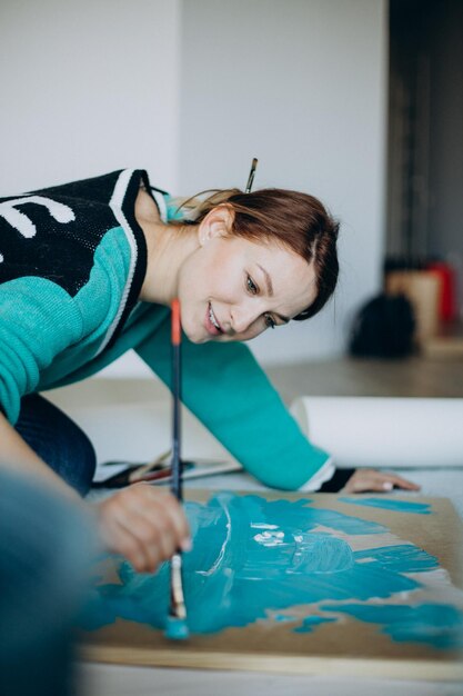 Mujer artista pintando un cuadro en casa