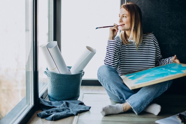 Mujer artista pintando un cuadro en casa