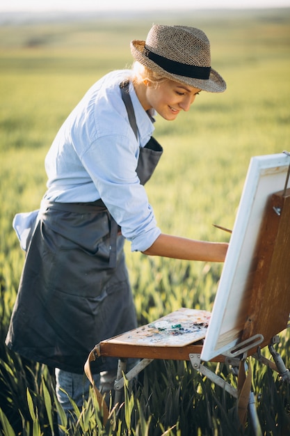 Foto gratuita mujer artista pintando con pinturas al óleo en un campo