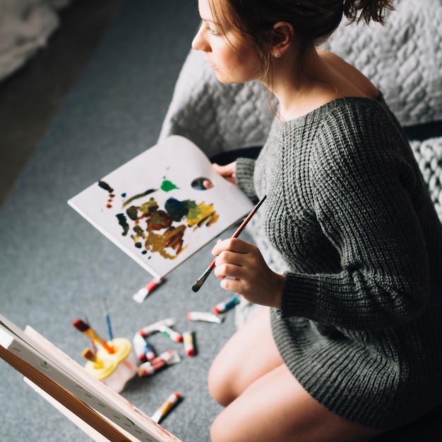 Mujer artista sujetando papel con acuarela