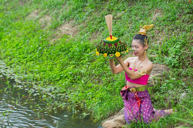 Mujer de Asia en traje tailandés tradicional mantenga kratong. Festival de loy krathong