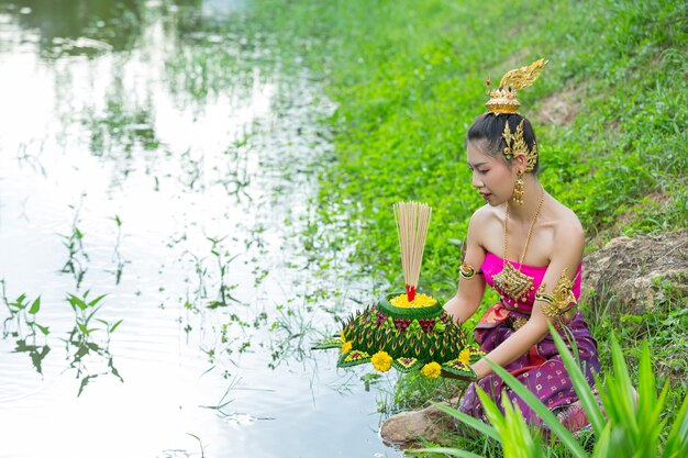 Mujer de Asia en traje tailandés tradicional mantenga kratong. Festival de loy krathong