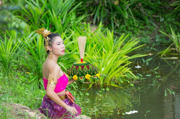 Mujer de Asia en traje tailandés tradicional mantenga kratong. Festival de loy krathong
