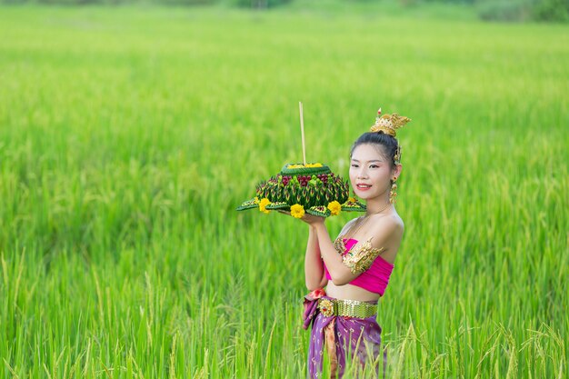 Mujer de Asia en traje tailandés tradicional mantenga kratong. Festival de loy krathong