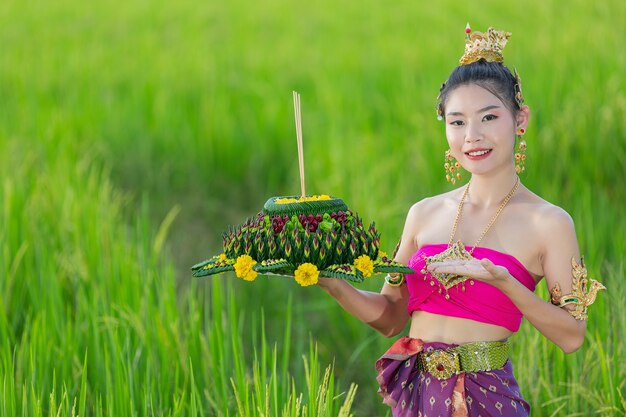 Mujer de Asia en traje tailandés tradicional mantenga kratong. Festival de loy krathong