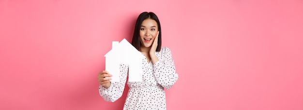 Foto gratuita mujer asiática adulta de bienes raíces que busca una casa modelo de casa y promoción sonriente de corredor com