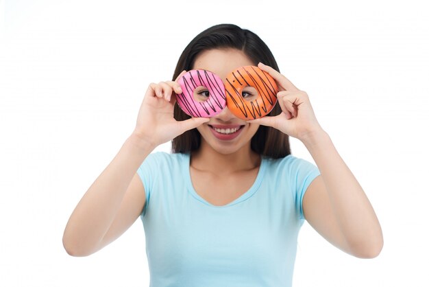 Mujer asiática alegre con donas apetitosas