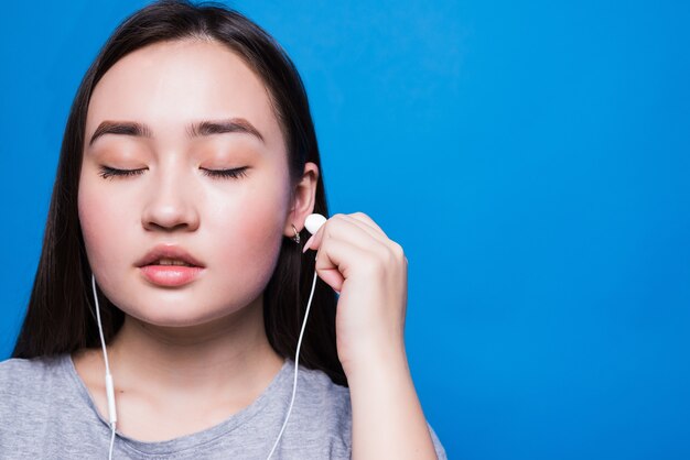 Mujer asiática con auriculares y escuchando música