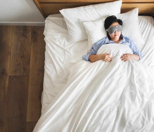 Mujer asiática en la cama durmiendo sola