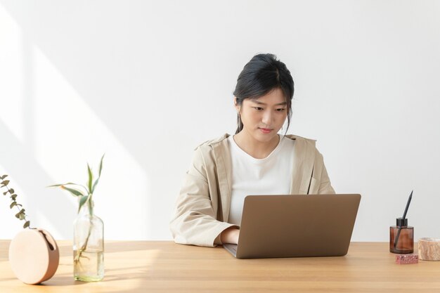 Mujer asiática en casa usando una computadora portátil