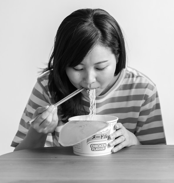 Mujer asiática comiendo fideos instantáneos