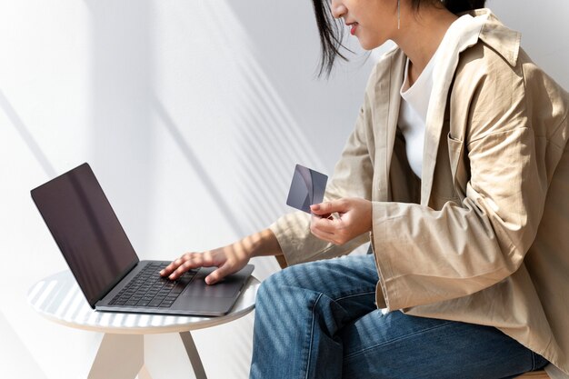 Mujer asiática de compras en línea usando su computadora portátil