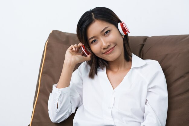 Mujer asiática contenido en los auriculares en el amortiguador