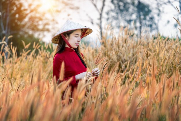 Mujer asiática con la cultura de Vietnam tradicional en el campo de flores de fuente africana.