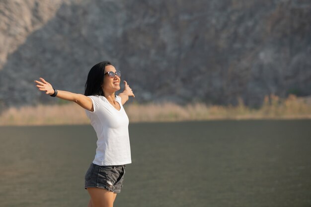 Mujer asiática disfrutando de la belleza de la naturaleza mirando el lago de la montaña