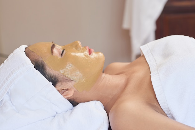 Mujer asiática disfrutando de procedimiento de cuidado de la piel