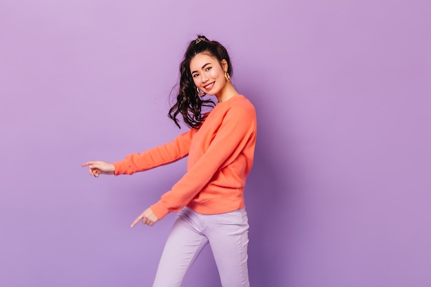 Foto gratuita mujer asiática emocionada en traje casual sonriendo a la cámara. disparo de estudio de bastante joven japonesa aislada sobre fondo púrpura.