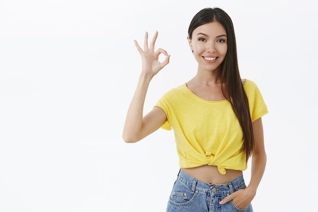 Mujer asiática encantadora segura y asertiva con cabello largo y oscuro y sin maquillaje que se siente hermosa