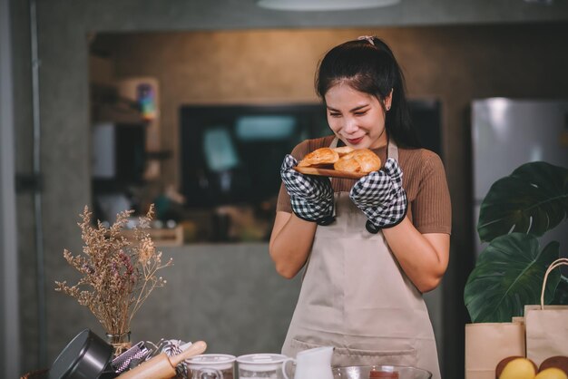 Mujer asiática feliz cocinando panadería casera en casa Poner en marcha el concepto de pequeña empresa SME