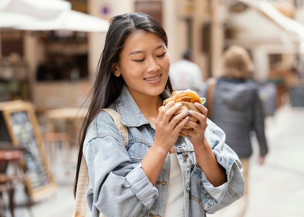 Mujer asiática feliz después de comprar comida en la calle