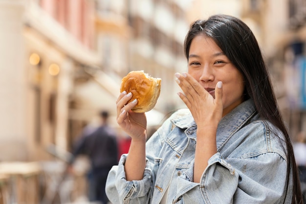 Mujer asiática feliz después de comprar comida en la calle