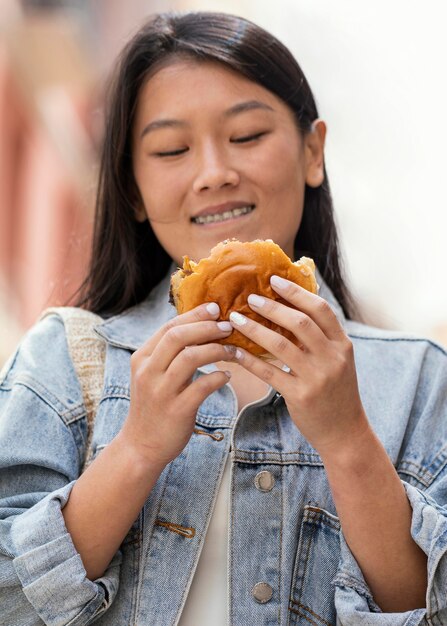 Mujer asiática feliz después de comprar comida en la calle