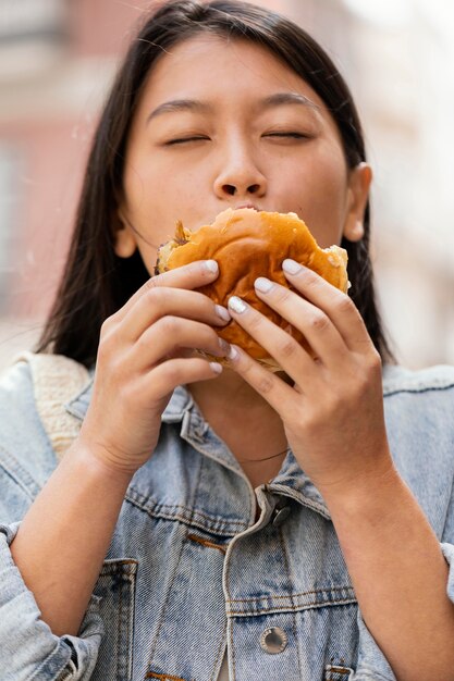 Mujer asiática feliz después de comprar comida en la calle