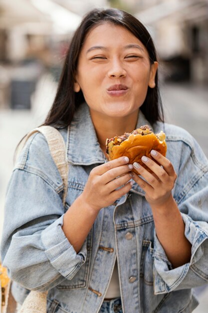 Mujer asiática feliz después de comprar comida en la calle