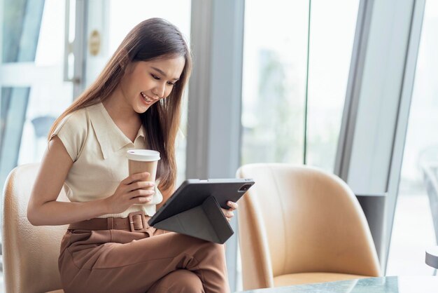 Mujer asiática freelance digital nómada carrera felicidad trabajo alegre sonriente trabajando en línea con dispositivo inteligente tableta teléfono inteligente ocupación en el extranjero proyecto trabajo en cualquier lugar nuevo estilo de vida sin marco