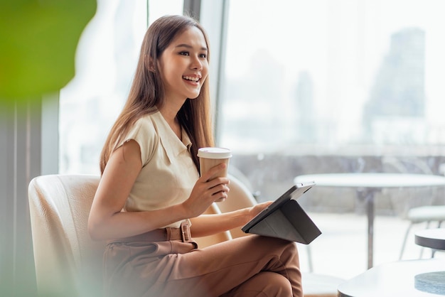 Mujer asiática freelance digital nómada carrera felicidad trabajo alegre sonriente trabajando en línea con dispositivo inteligente tableta teléfono inteligente ocupación en el extranjero proyecto trabajo en cualquier lugar nuevo estilo de vida sin marco