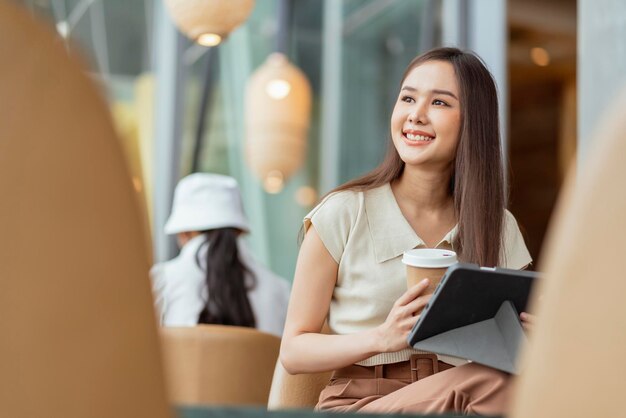 Mujer asiática freelance digital nómada carrera felicidad trabajo alegre sonriente trabajando en línea con dispositivo inteligente tableta teléfono inteligente ocupación en el extranjero proyecto trabajo en cualquier lugar nuevo estilo de vida sin marco