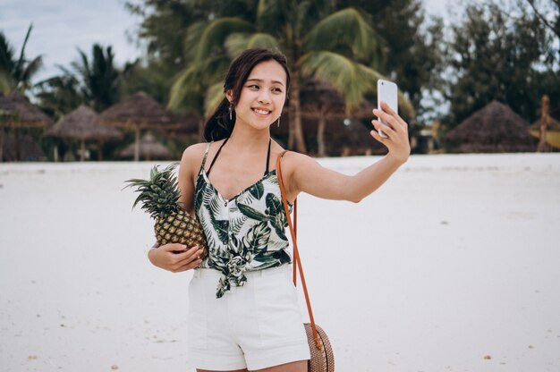 Foto gratuita mujer asiática hablando por teléfono en la playa