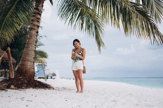 Foto gratuita mujer asiática hablando por teléfono en la playa