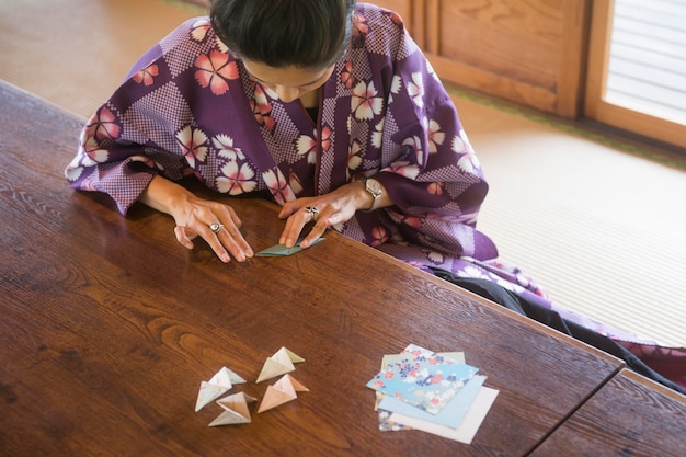 Foto gratuita mujer asiática haciendo origami con papel japonés