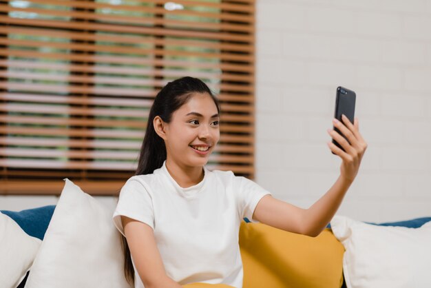 Mujer asiática joven del adolescente que usa videoconferencia del smartphone