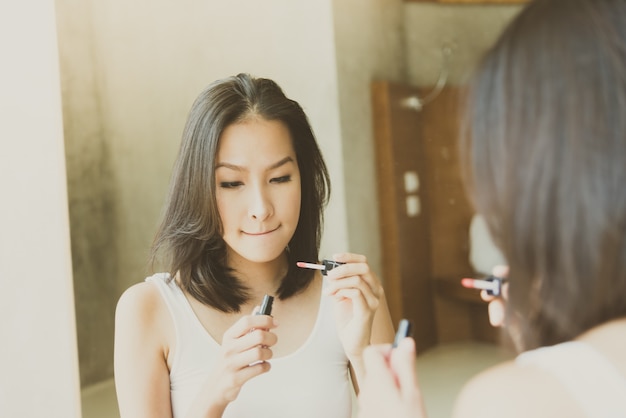 La mujer asiática joven se compone