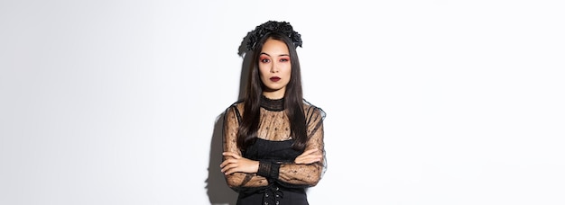 Foto gratuita mujer asiática joven escéptica en traje de bruja o viuda que parece una mujer dudosa vestida para hallowee